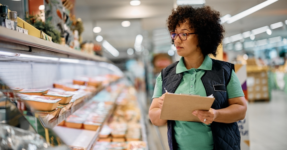 Supermarket manager analyzing inventory using tablet