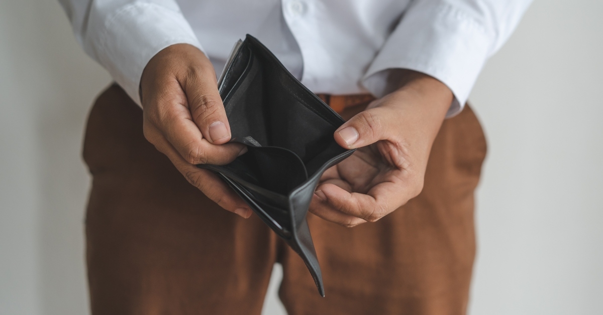 opening his empty wallet