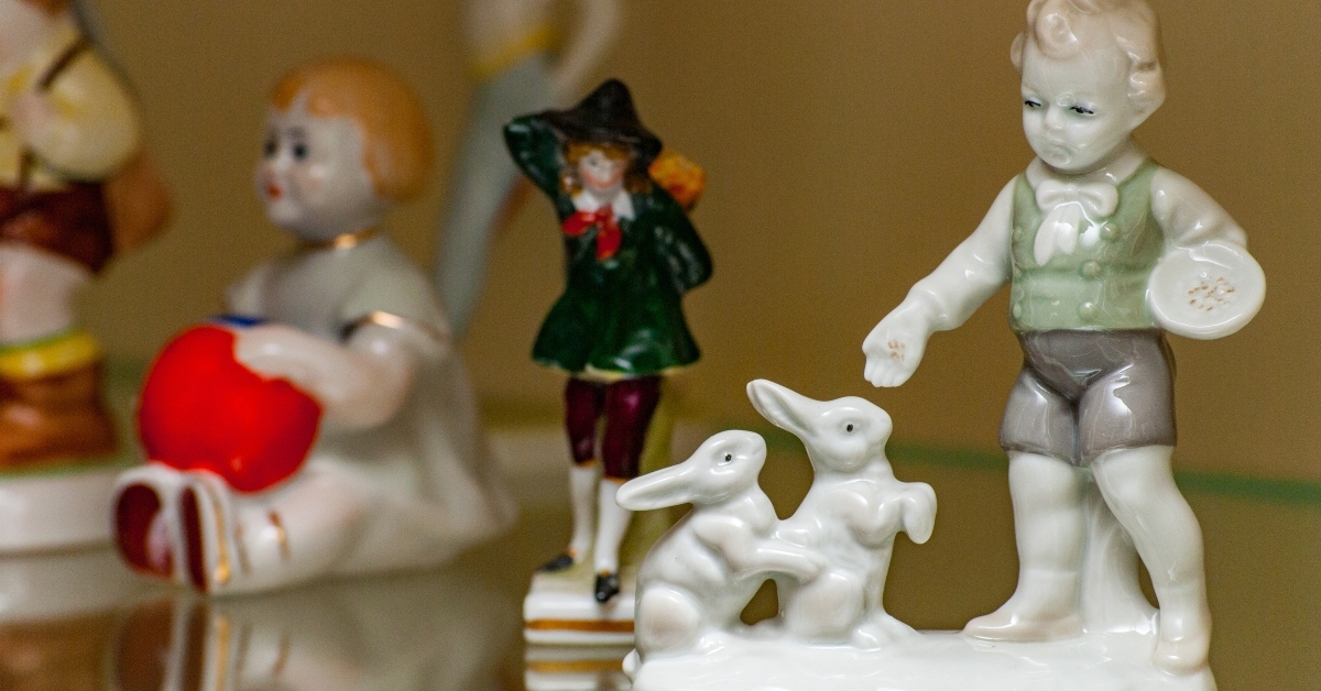 Boys and bunny porcelain figurine on shelf along with others
