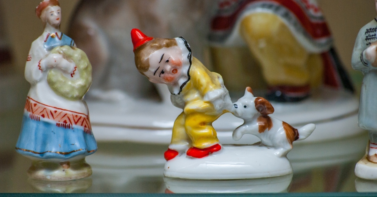 Dog bites boy porcelain figurine on shelf