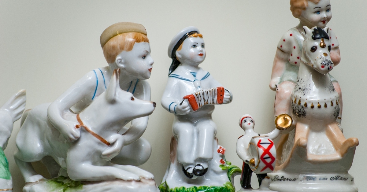 Boy with dog and boys playing instruments porcelain figures on a shelf