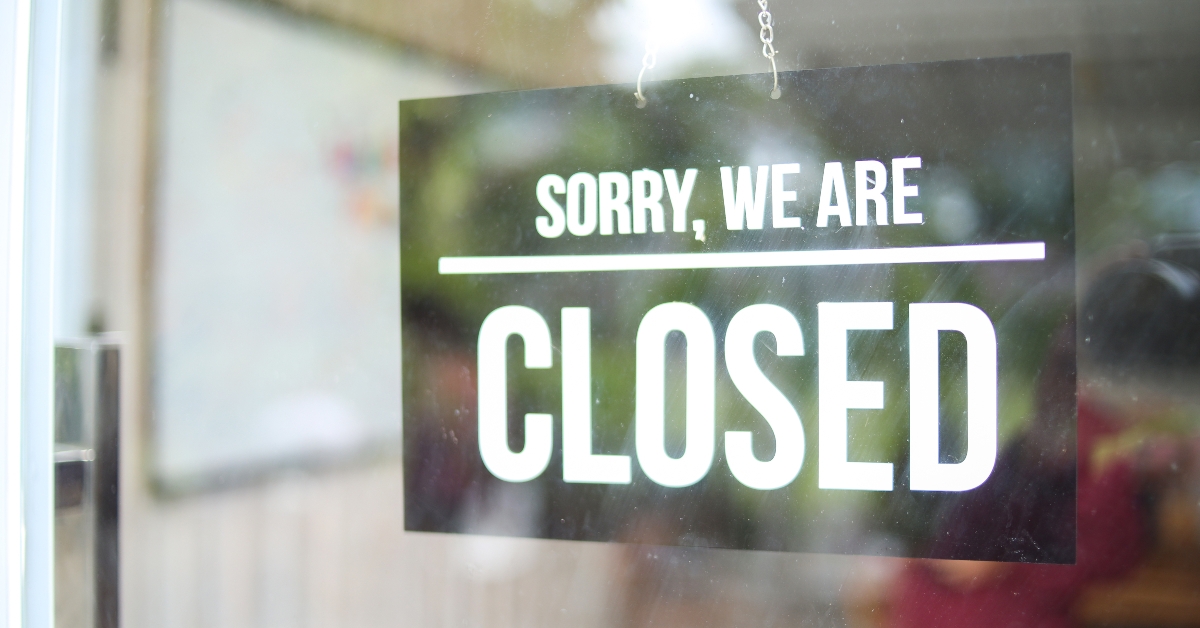 A Black Sign Hanging On Glass Door