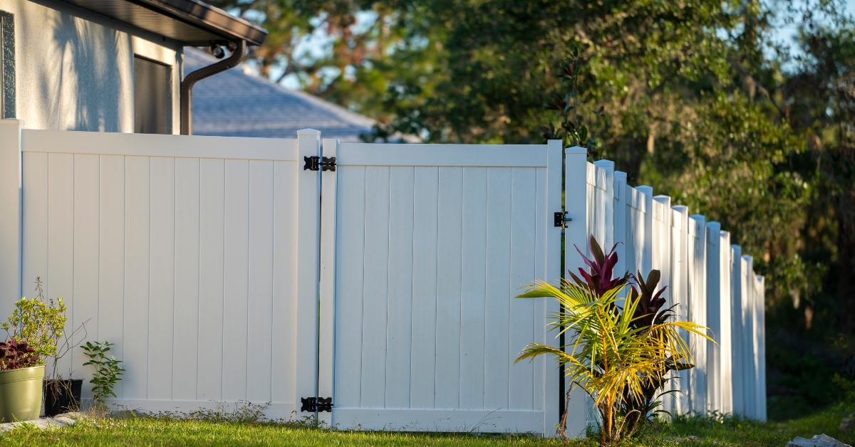 white vinyl picket fence on green lawn