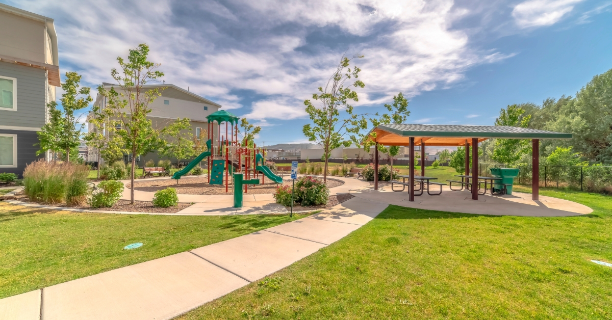 Park at a sunny neighborhood with children's playground and pavilion eating area 