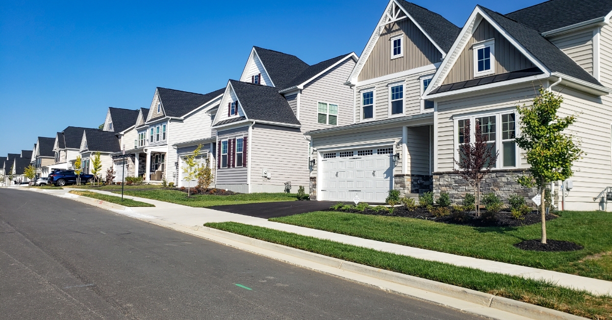 Picturesque street view with modern homes under blue skies. A row of modern detached homes.