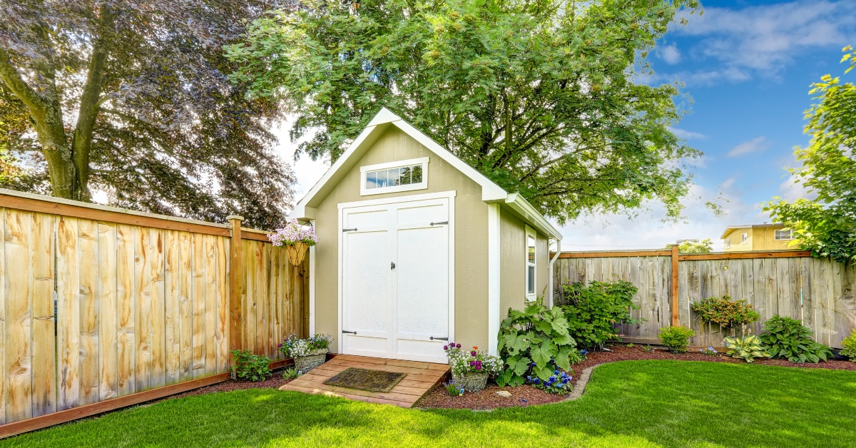 fenced backyard with small shed 