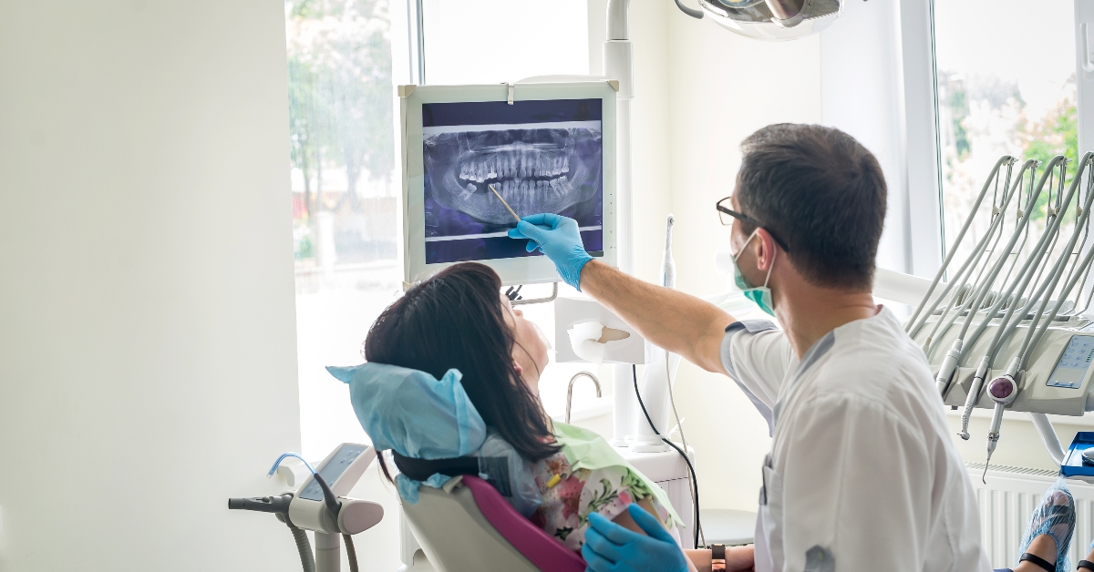 Doctor dentist showing patient's teeth on X-ray