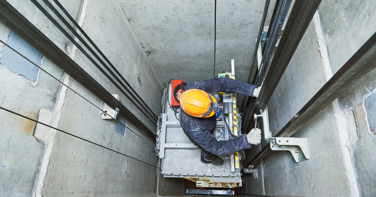 lift machinist repairing elevator in lift shaft