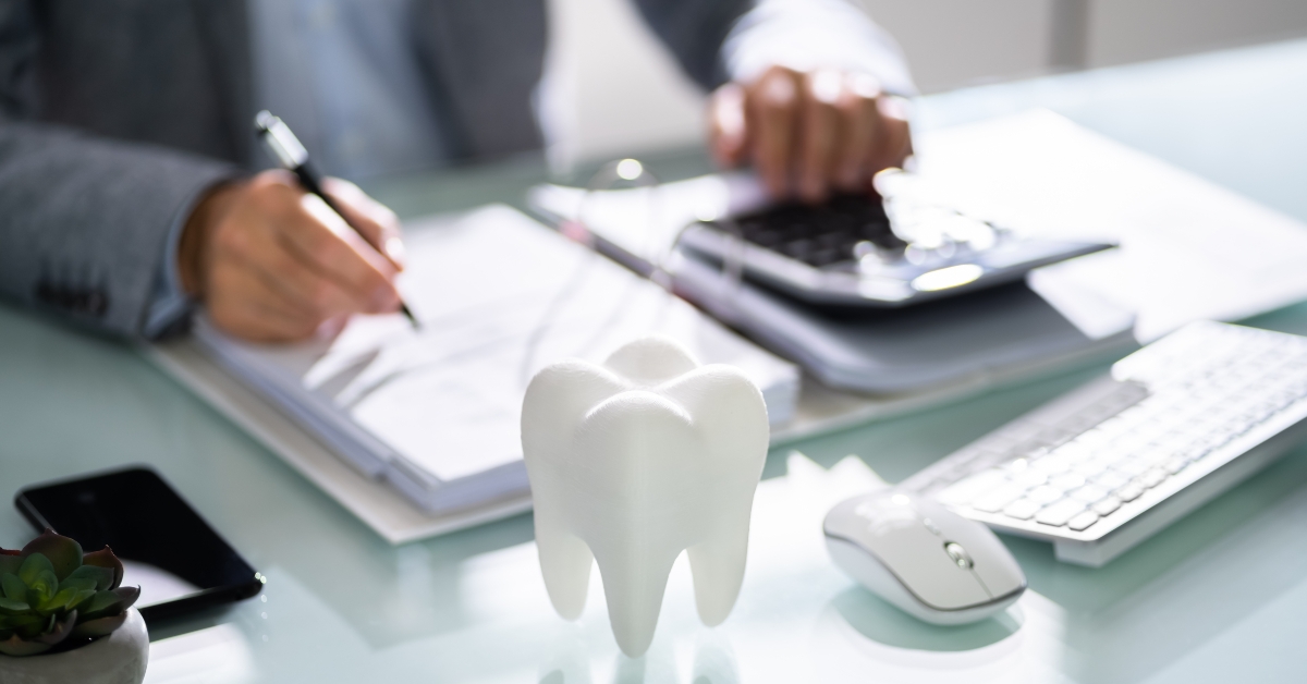 Tooth In Front Of Businessperson Calculating Bill