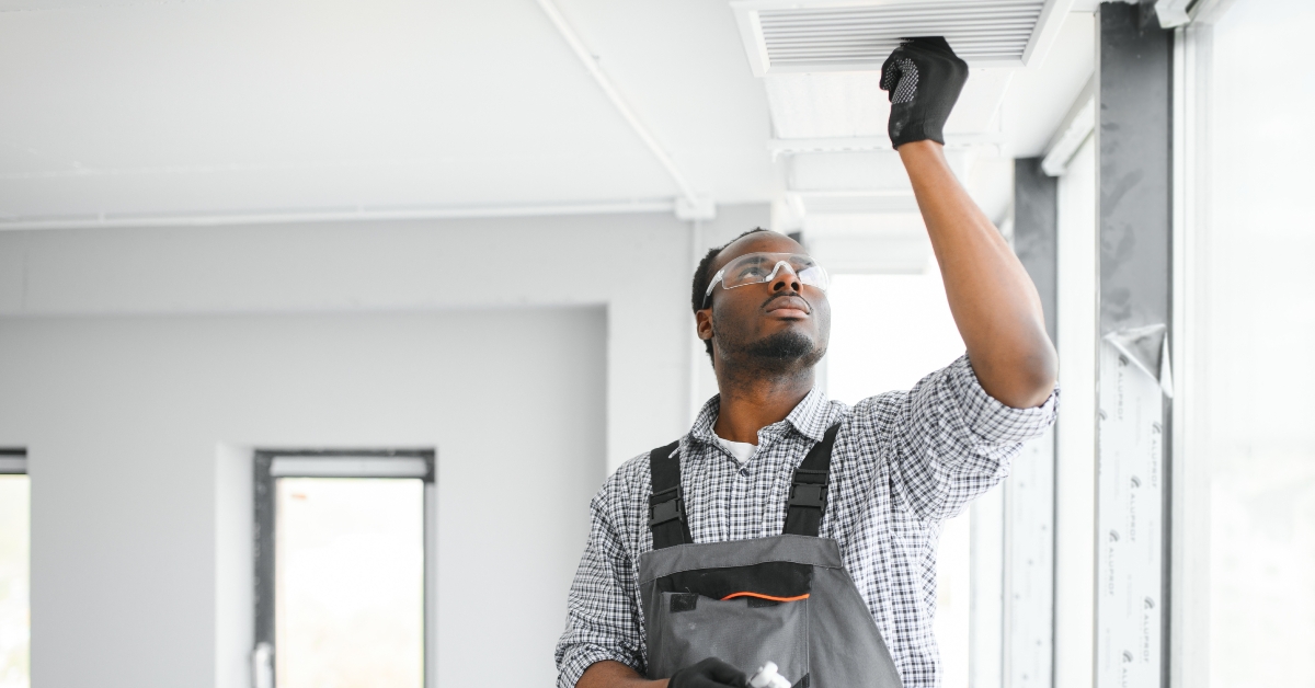 hvac worker installing ducted pipe system