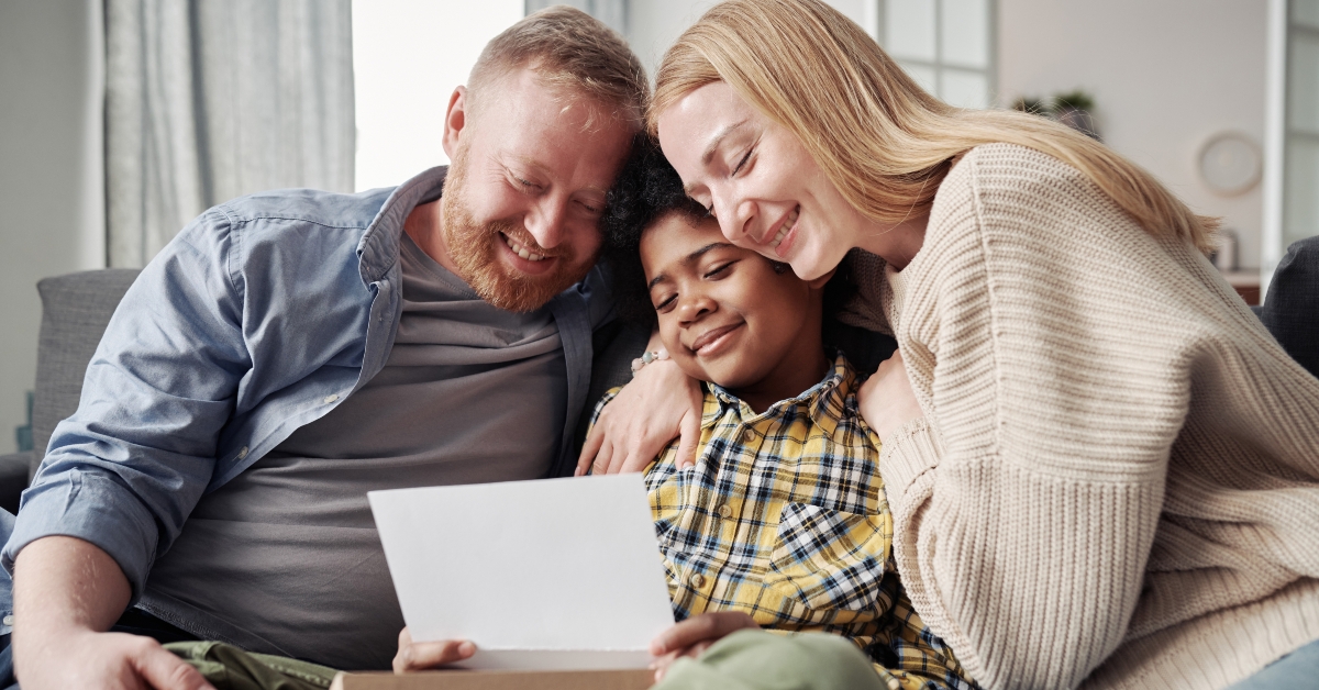 Happy parents embracing their African adoptive son