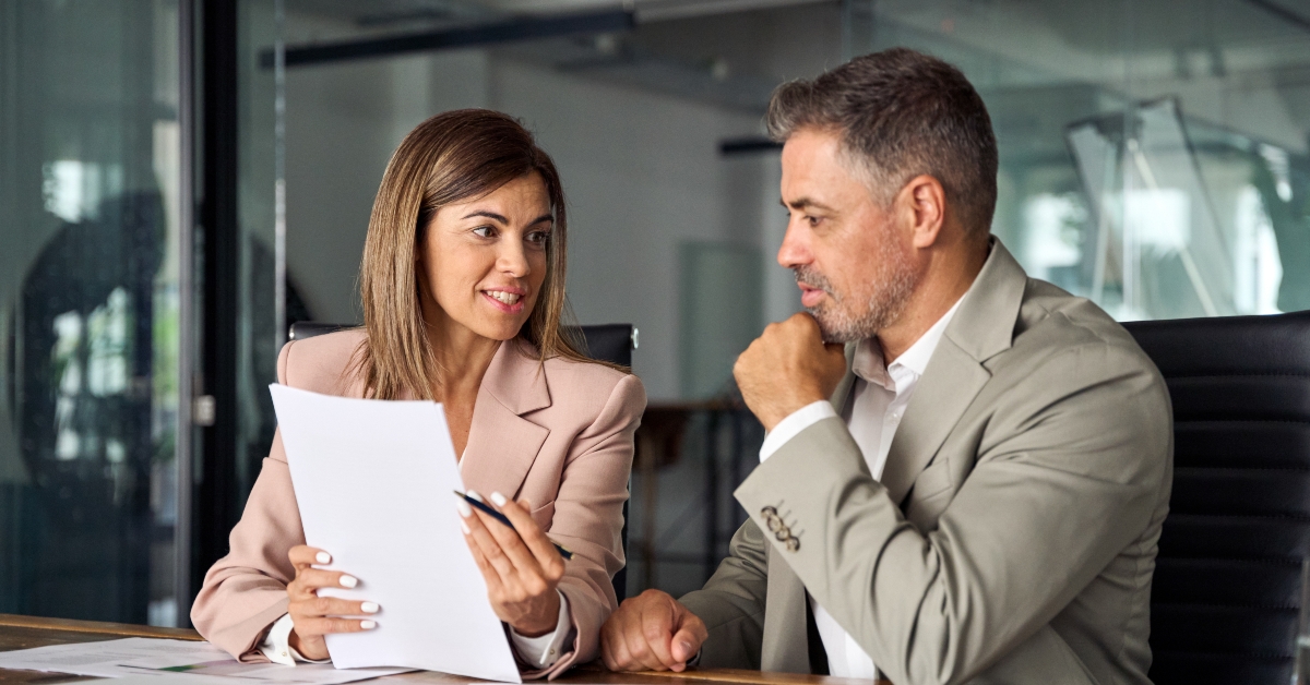 two business executives discussing financial accounting documents report