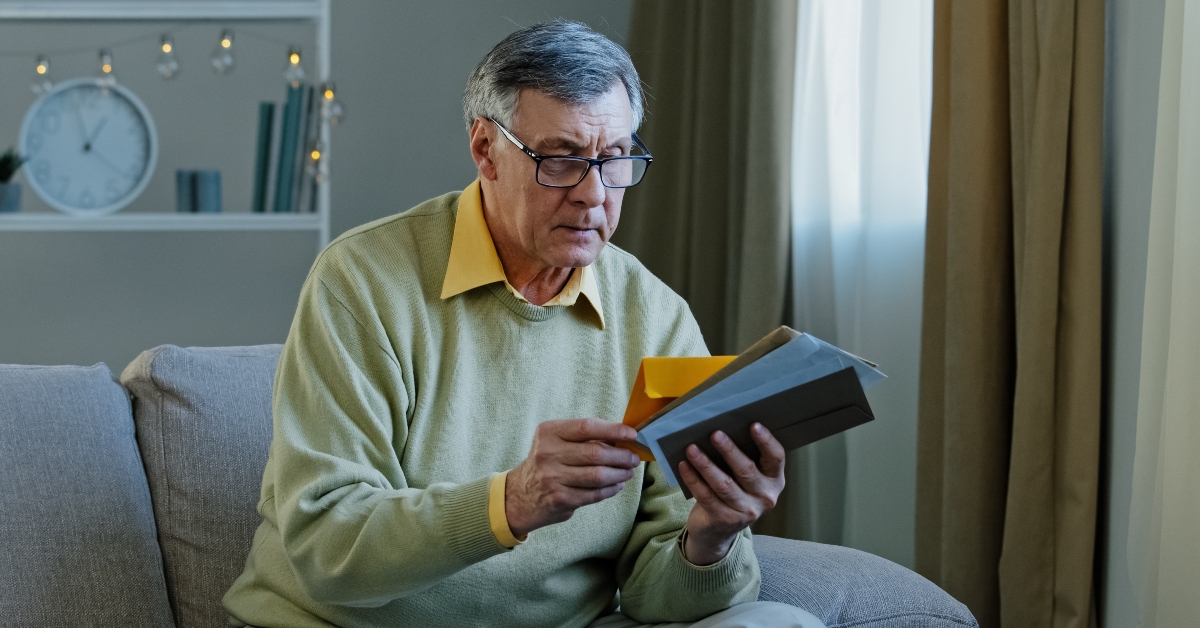 Caucasian man checking sorting letters in living room