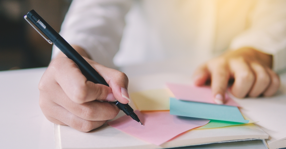 business hand writing on an adhesive note