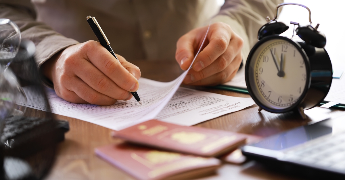 person signing document with passport 
