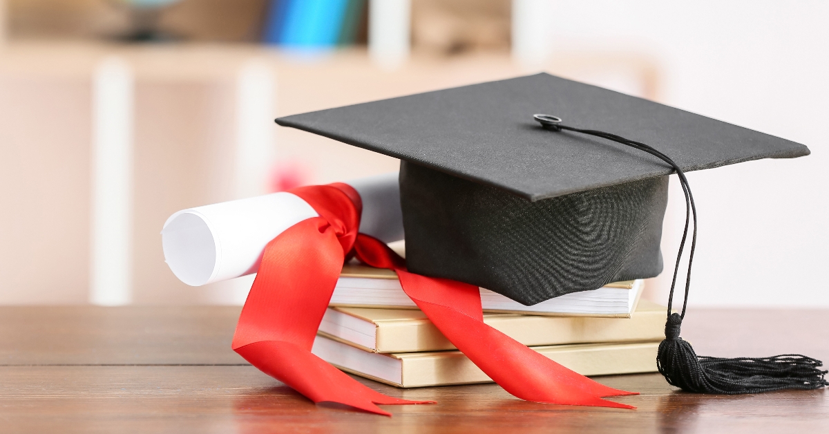 graduation hat diploma and books on table