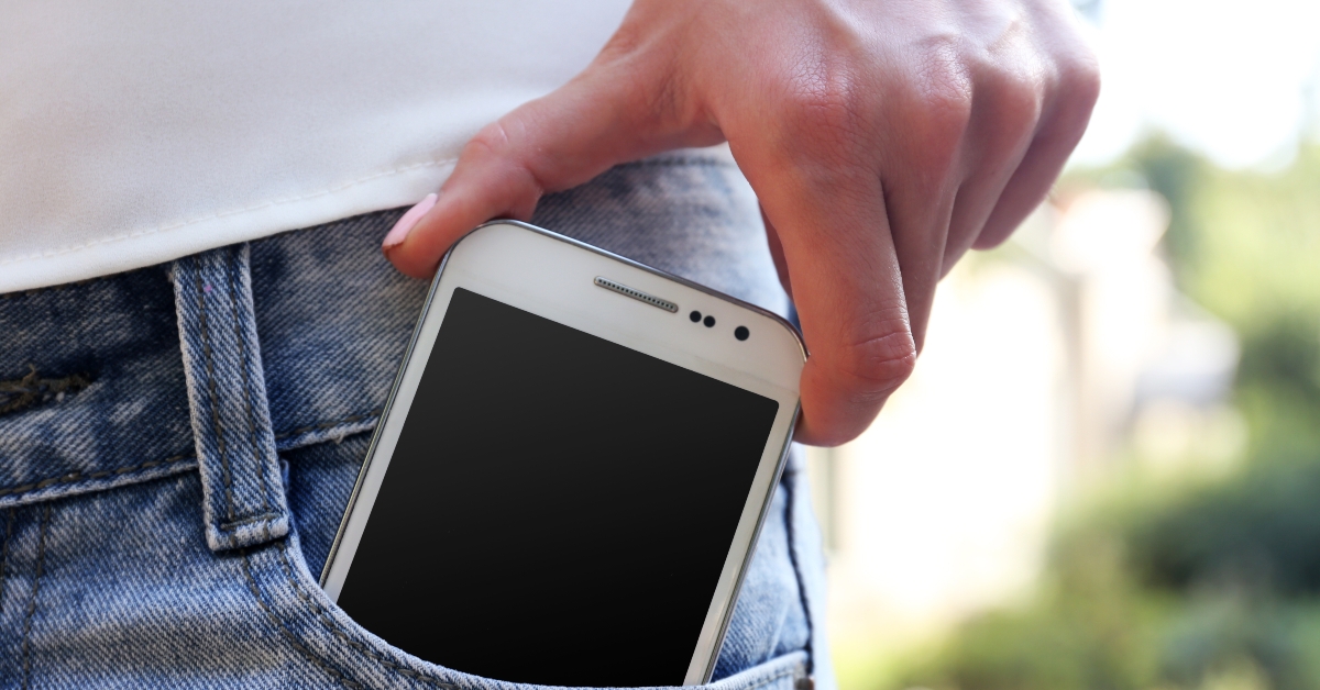 white smart mobile phone in jeans pocket 