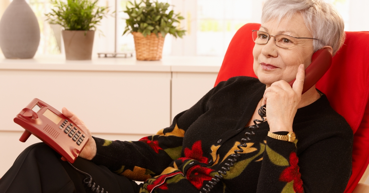 Pensioner woman using landline phone