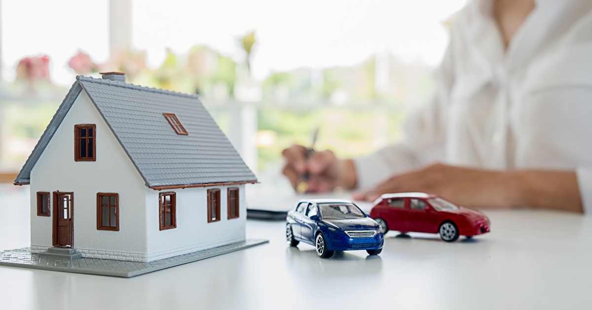 car and house model with agent and customer discussing for contract