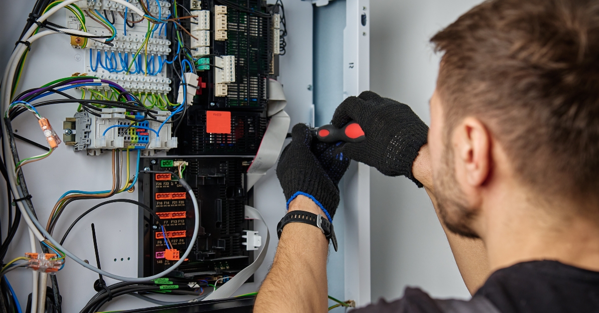 technician working on internal wiring of heat pump