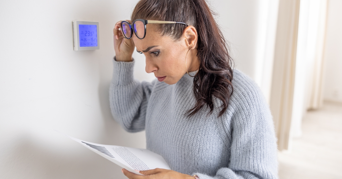 woman standing next to a thermostat