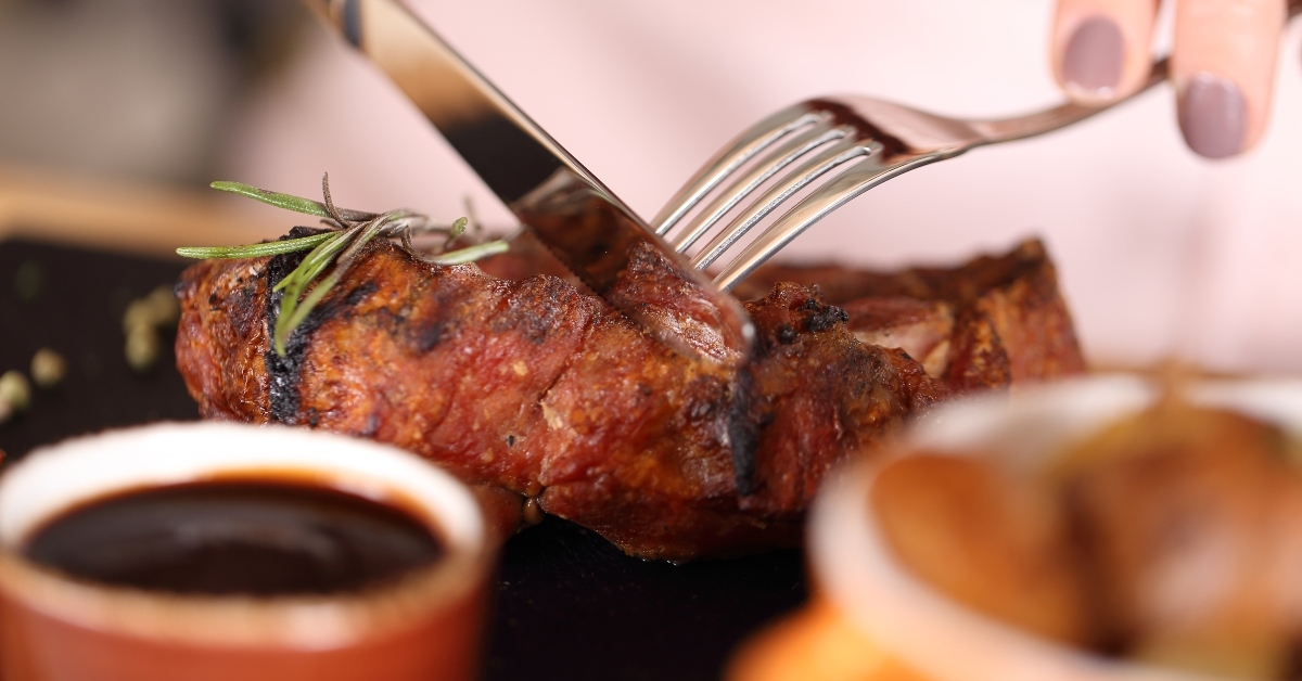 woman eating steak in a restaurant 