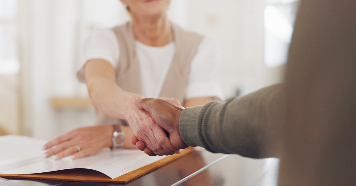 senior woman and man shaking hands for business meeting
