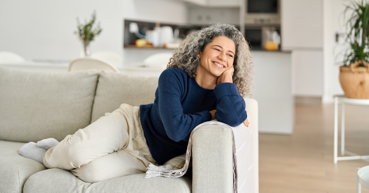 happy woman laying on sofa