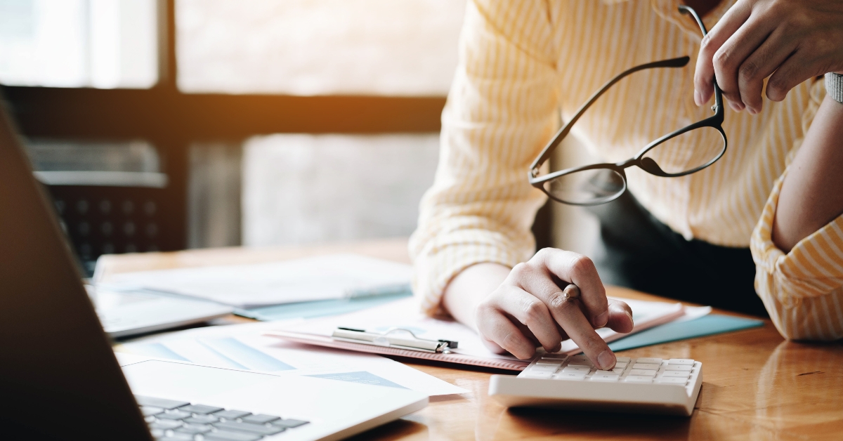woman using calculator and laptop
