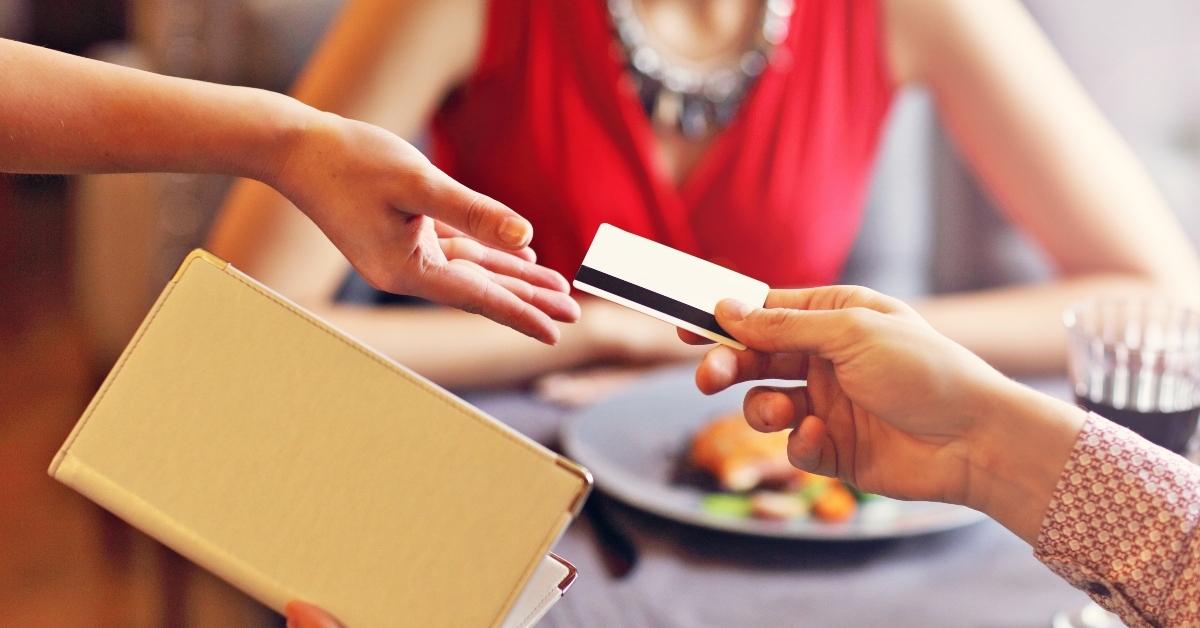 people paying in restaurant by credit card reader