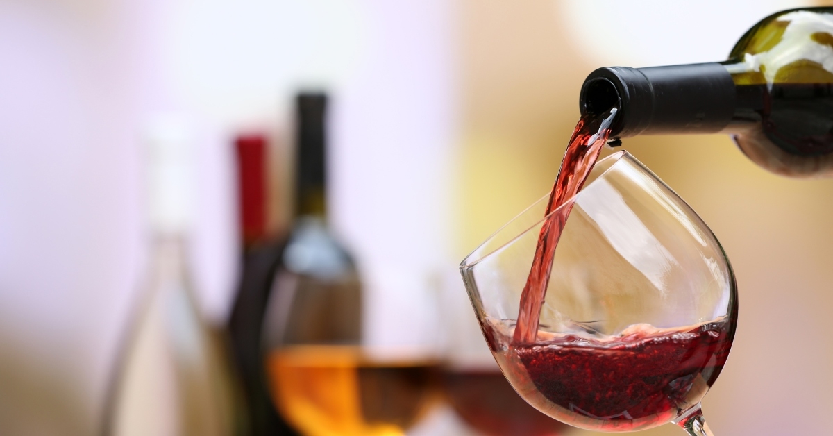 red wine puring into wine glass close up