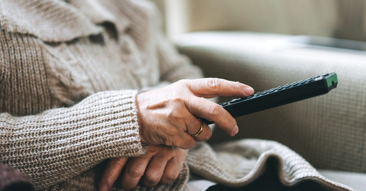 elderly hand holding remote television 