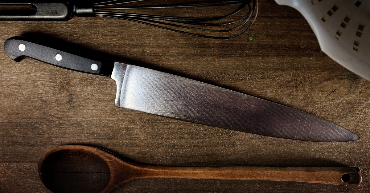 Black handle kitchen knife on top of the board