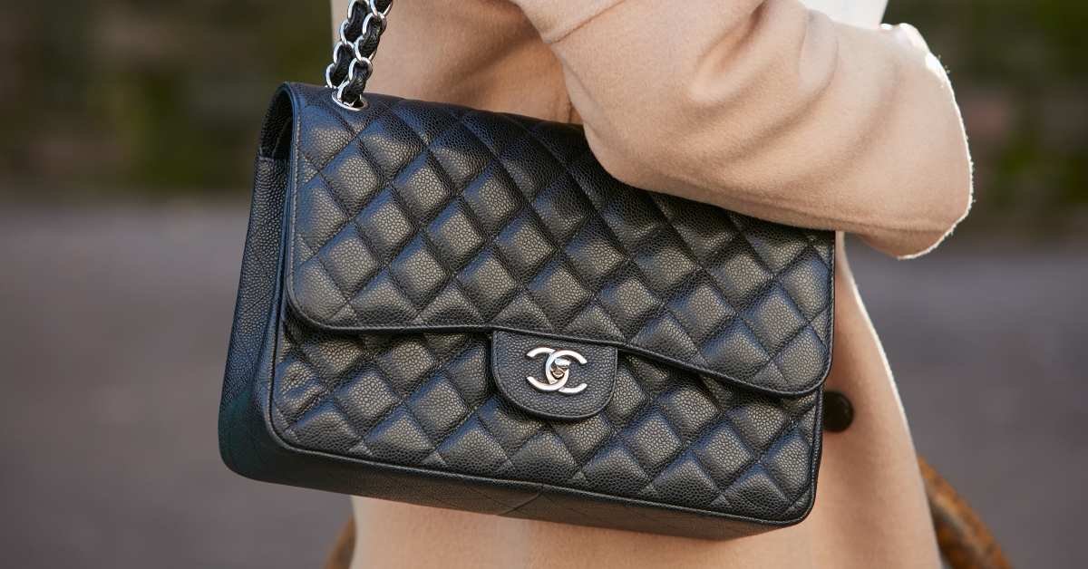 black leather Chanel bag and beige jacket