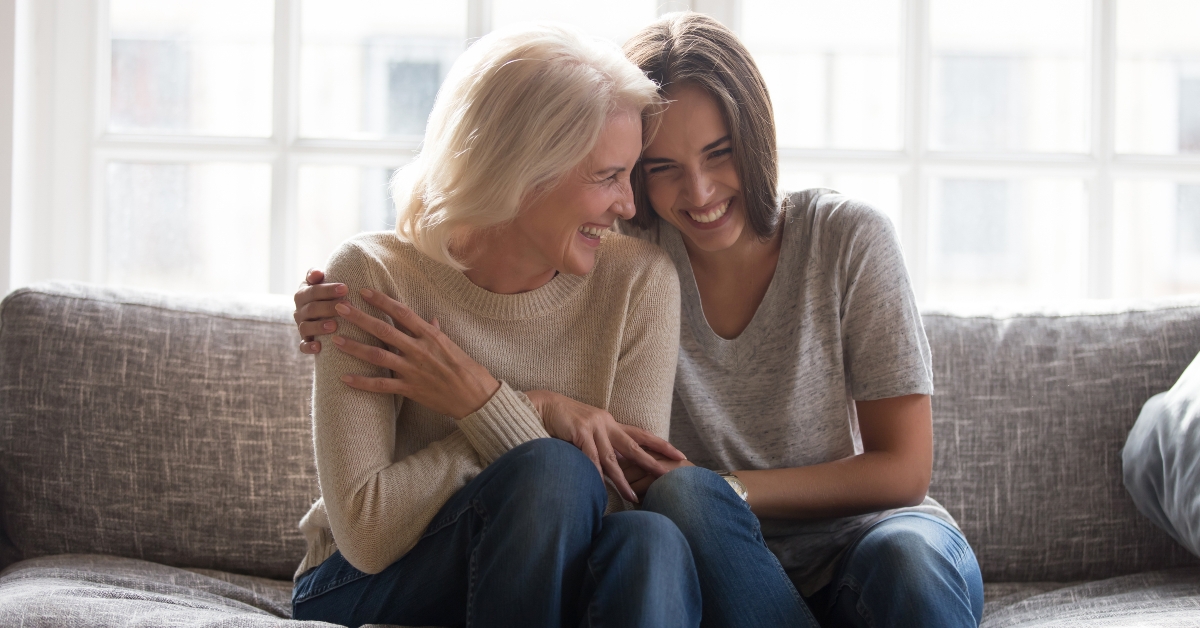 daughter and mother sitting on sofa