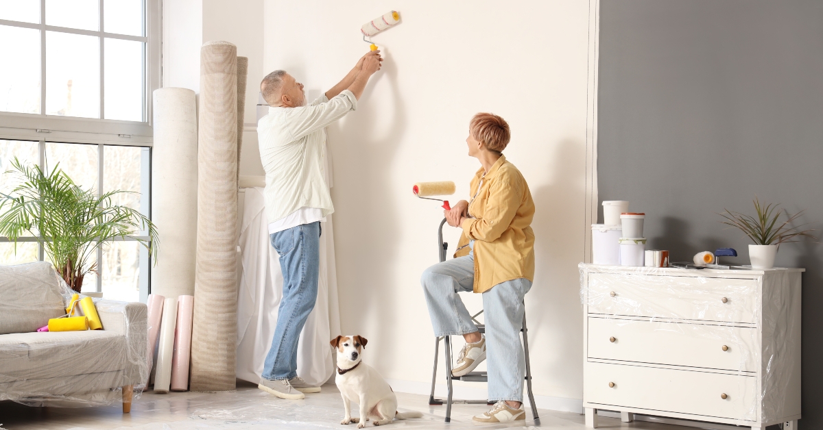 mature couple with dog painting wall