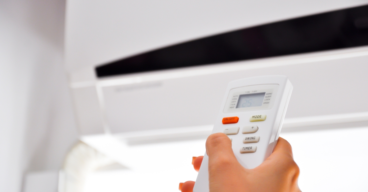 person holding air condition remote control