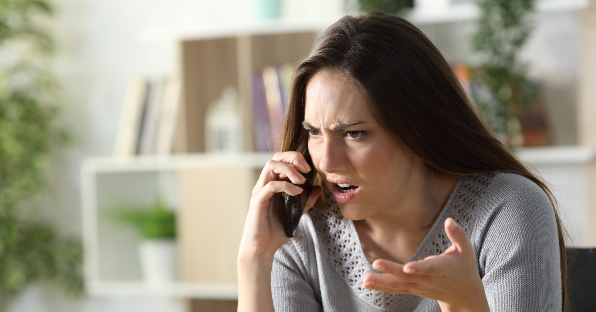 angry woman calling arguing on phone at home