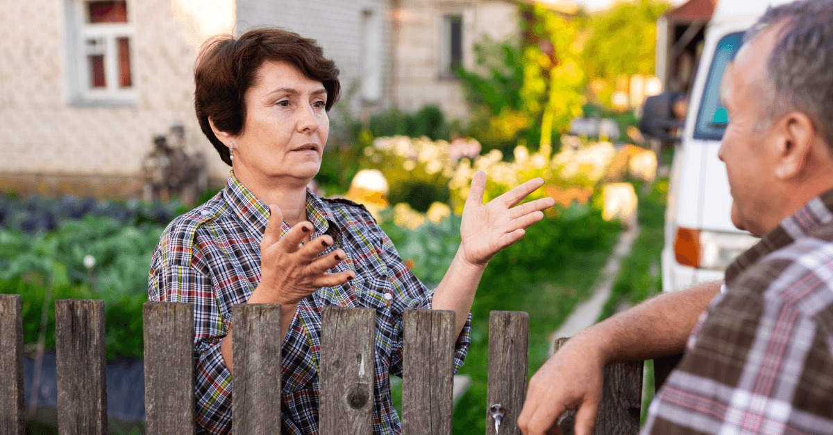 Neighbors man and woman chatting near the fence