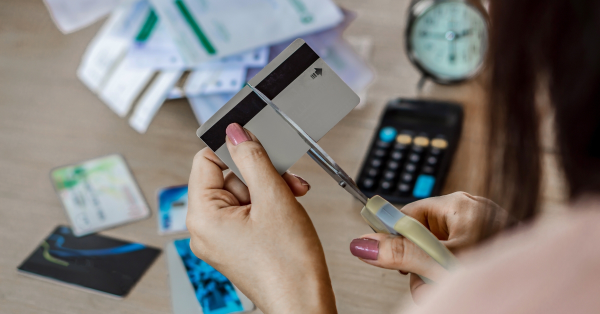 woman hand cutting credit cards 