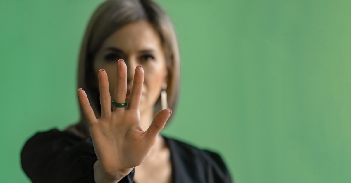 young woman in dark clothes shows palm