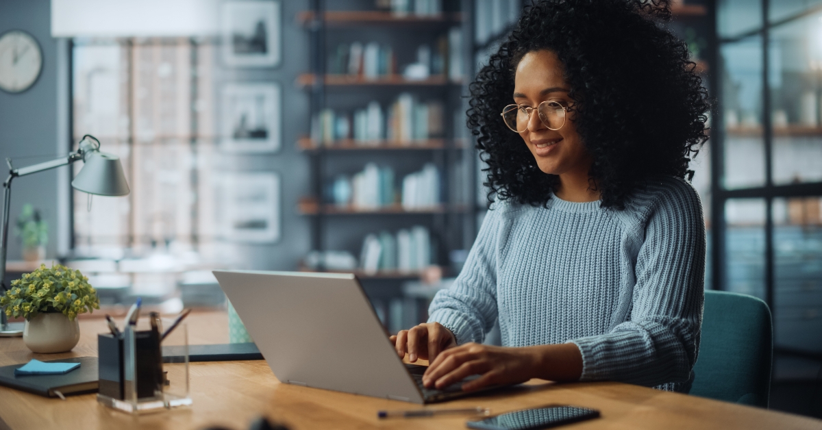 female sitting at desk using laptop at home