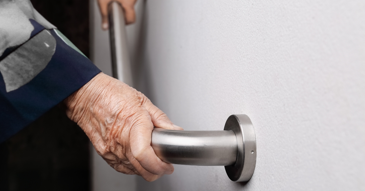 Elderly woman holding on handrail