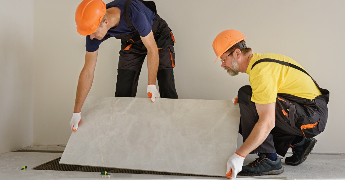 two person installing a large ceramic tile