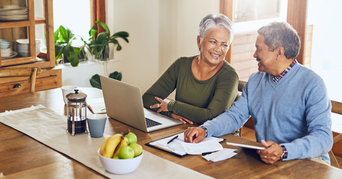 happy senior couple with bills