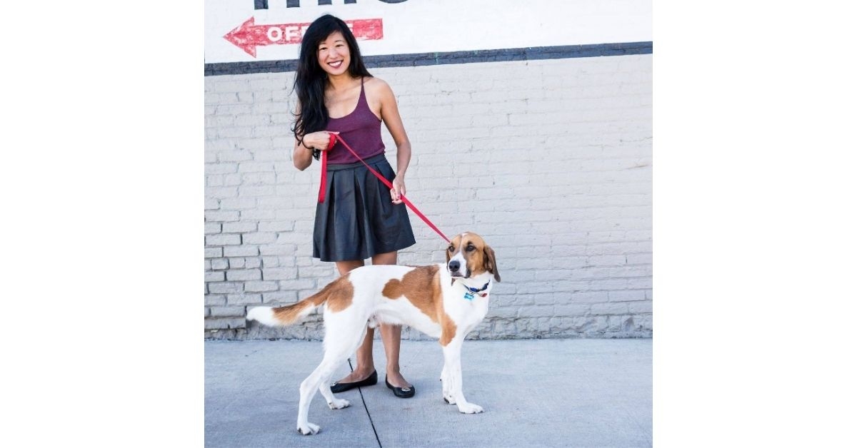 Person holding a leash beside her dog