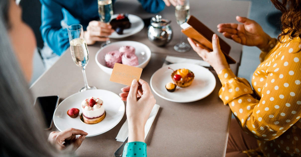 three ladies paying for order in cafe 