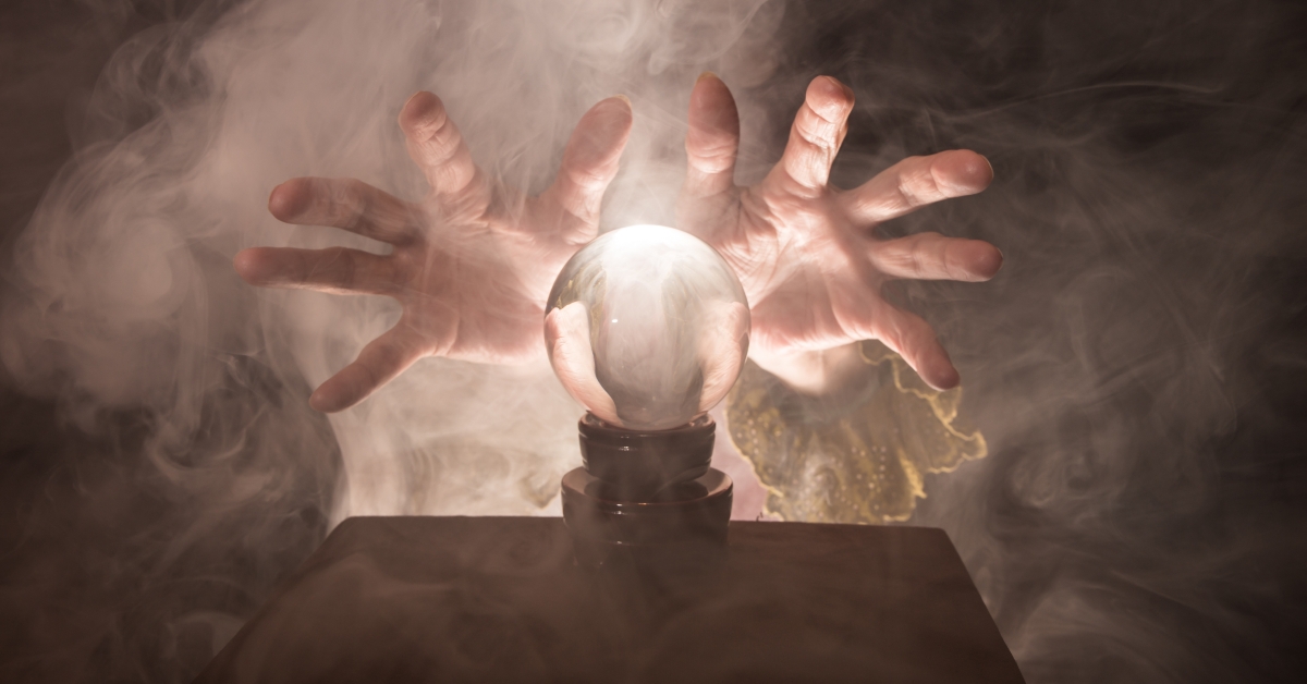 a fortune tellers hands conjure up a crystal ball