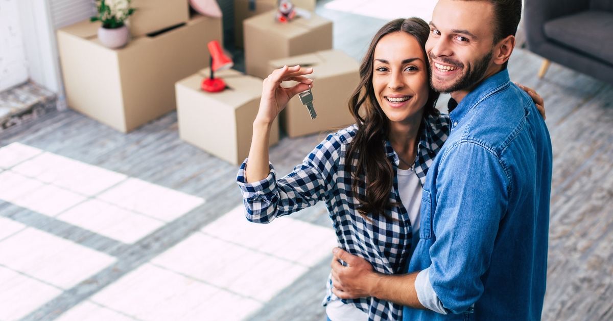 couple holds happily a key to their new home