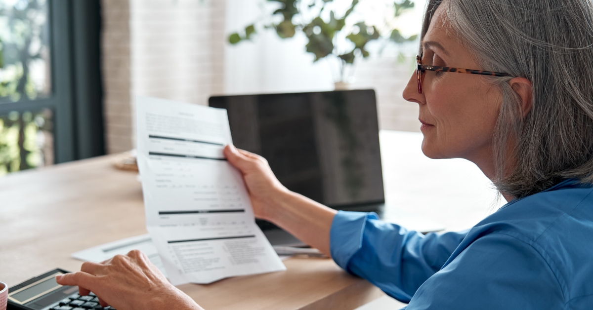 business woman holding paper bill using calculator